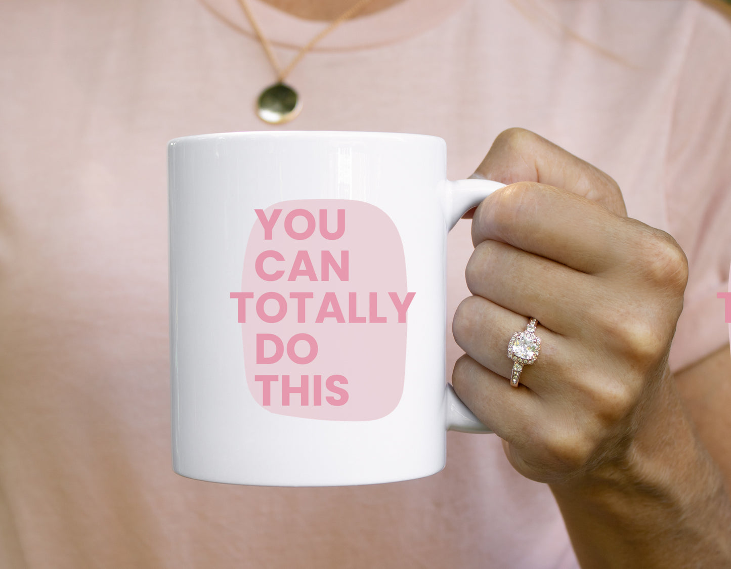 Person holding a mug with 'You can totally do this' text on a pink background