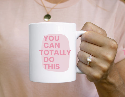 Person holding a mug with 'You can totally do this' text on a pink background