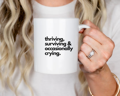 Funny Coffee Mug – “Thriving, Surviving, and Occasionally Crying” | Ceramic Mug for Self-Care & Laughs